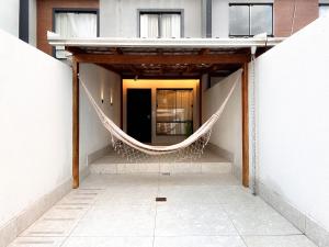 uma rede pendurada do lado de um edifício em Casa com Jacuzzi próximo ao teleférico, aquário, Greenvalley e praia! em Camboriú