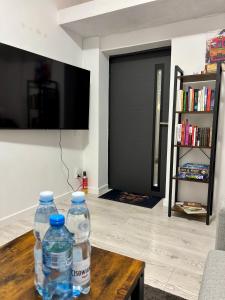 twee waterflessen op een houten tafel in de woonkamer bij Elephant Studio in Wrocław