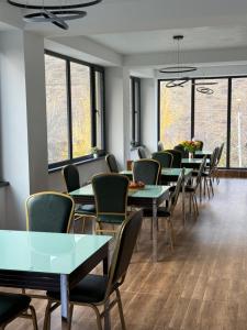 a waiting room with tables and chairs and windows at Green Hills Resort in Hankʼavan