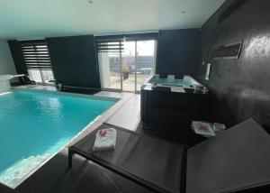 a large bathroom with a large swimming pool at Nuit Détente Rodez in Rodez
