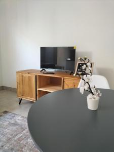 Una sala de estar con una mesa y un televisor. en Atloch, en Kimberley