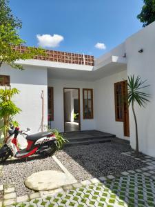 a scooter parked in front of a white house at Bring In House Yogyakarta in Yogyakarta