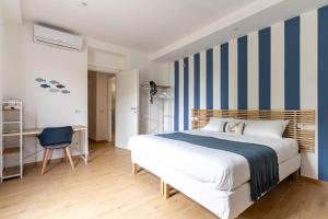 科莫Como Lake Chic Retreat的一间卧室配有一张床和蓝白色条纹墙