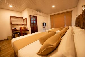 a hotel room with two beds and a television at Zircon Ella in Ella
