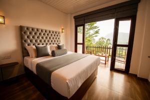 a bedroom with a large bed with a large window at Zircon Ella in Ella