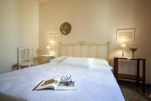 een bed met een boek en een bril erop bij Residenza "I Tre Carrubi " in Fasano