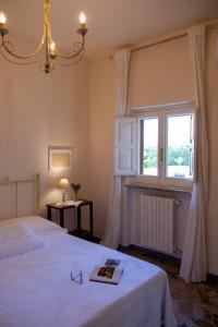 een slaapkamer met een wit bed en een raam bij Residenza "I Tre Carrubi " in Fasano