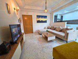 チュニスにあるLes jardins du lac 2のソファとテレビのあるリビングルーム