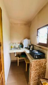 een kleine keuken met een wastafel en een raam bij Minerva Apart in Ranomafana