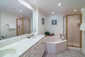 a bathroom with a tub and a shower and a sink at Sandpiper #108 in Tybee Island +23 photos