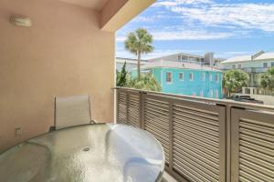 a balcony with a glass table and a blue building at Sandpiper #108 in Tybee Island