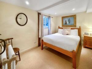 ein Schlafzimmer mit einem Bett, einem Spiegel und einem Fenster in der Unterkunft Manor Cottage in Cavendish