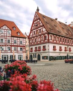 a group of buildings in a courtyard with flowers at Central Apartment Nördlingen in Nördlingen
