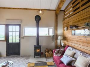 sala de estar con chimenea y sofá rojo en Cowlas, en Aberhosan 10 fotos más