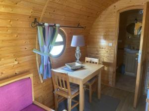 Holzhütte mit einem Tisch und einem Fenster in der Unterkunft Roulotte au domaine du Bouygues in Salvagnac-Cajarc