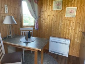 ein Esszimmer mit einem Tisch und einem Fenster in der Unterkunft Roulotte au domaine du Bouygues in Salvagnac-Cajarc + 4 Fotos