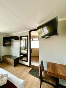 una habitación con una cama, un escritorio y un televisor en Tikala Cusco Boutique Hotel, en Cusco