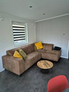 a living room with a brown couch and a table at Chalet La Diga in Mariënberg