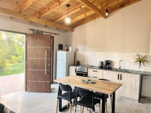 a kitchen with a wooden table and a refrigerator at Village De Las Sierras in Sierra de la Ventana