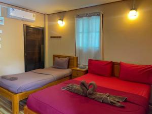 Ban Song (1)にあるบ้านสวนเปรมณัฐตราのタオルが敷かれたベッドが2つある部屋