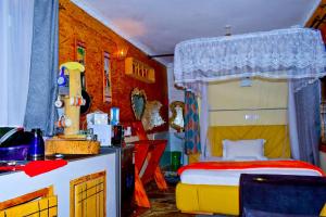 Hakuna Matata Gardens في Migori: غرفة نوم بها سرير وطاولة ومطبخ