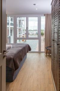 a bedroom with a bed and a large window at Dockside Travemünde in Travemünde +232 photos