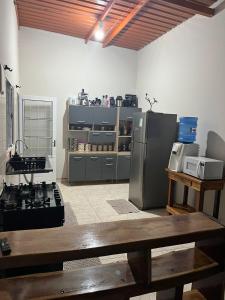 a kitchen with a stainless steel refrigerator and a table at Casa Roxa in Bonito