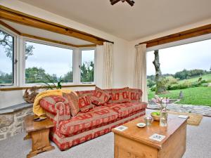 ein Wohnzimmer mit einem roten Sofa und großen Fenstern in der Unterkunft Exmoor View in Barbrook