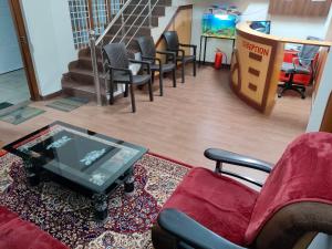 une salle d'attente avec des chaises et une télévision sur une table dans l'établissement SHREVIK Comforts, à Chikmagalur 18 autres photos
