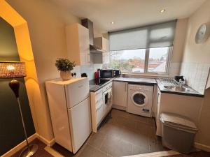 a small kitchen with a washer and dryer in it at #81 Stylish Top Floor - for 2 - 10 mins to Brueton Park - " Perfect for Business Traveler and Couple - Free Parking" in Shirley