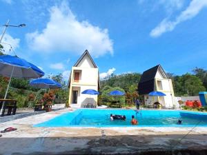 a house and a swimming pool with people in it at Embun Pagi Alami in Telukladang +11 photos