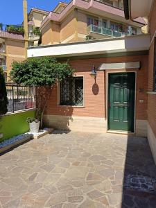 a green door on a building with a sidewalk at Casa Mille Lire in Ciampino