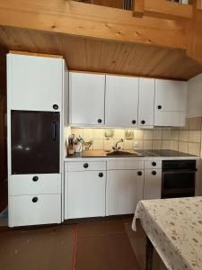 a kitchen with white cabinets and a sink at Fewo Mit Herz in Horboden +32 photos