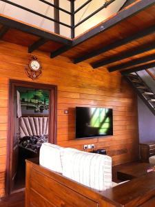ein Wohnzimmer mit einem weißen Sofa und einem Fernseher in der Unterkunft Tidenest Cottage in Nuwara Eliya