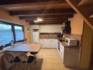 a kitchen with a wooden table and chairs in it at Erzgebirgshütte in Pobershau