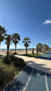 a road next to a beach with palm trees at Palita Vita - Durrës Beach in Durrës