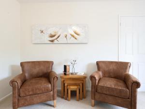 two chairs and a table with a picture on the wall at Heysham Retreat in Evesham +12 photos