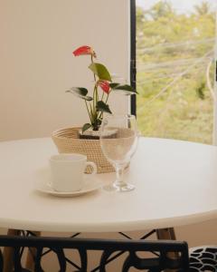 una mesa con un plato y una taza y una planta en Loft Aconchegante & bem localizado II, en Santo Antônio dos Prazeres