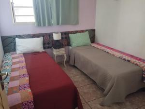 une chambre avec deux lits et une fenêtre dans l'établissement Casa em Tiradentes, à Tiradentes