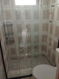 une douche avec une porte vitrée à côté des toilettes dans l'établissement Casa em Tiradentes, à Tiradentes 3 autres photos