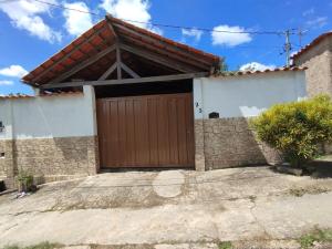 une maison avec une grande porte de garage en bois dans l'établissement Casa em Tiradentes, à Tiradentes