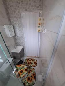 a small bathroom with two pizzas on the floor at Kitnet dos netos in Ubatuba