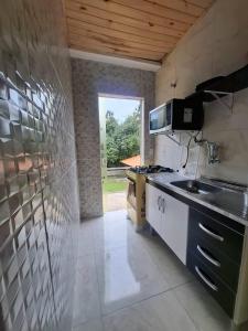 a kitchen with a sink and a stove top oven at Kitnet dos netos in Ubatuba