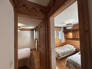 a bedroom with two beds and a mirror in a room at Superbe Appartement 4P 6 Pers avec Piscine et Parking à Méribel - FR-1-180-598 in Les Allues