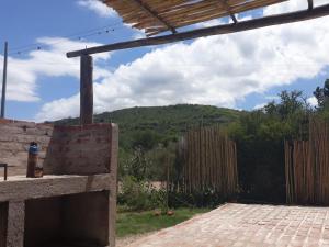 a patio with a fence and a mountain in the background at Casa Las Rosas in La Cumbre