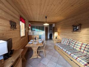a living room with a couch and a table in a cabin at Appartement cosy 2 pièces avec wifi à Méribel - FR-1-180-663 in Chandon