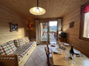 a wooden living room with a table and a couch at Appartement cosy 2 pièces avec wifi à Méribel - FR-1-180-663 in Chandon