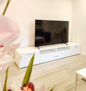 un centre de divertissement blanc avec une grande télévision dans un salon dans l'établissement Flair-Apartments 'SALZ & FLAIR' nähe Altstadt, 450 m Bahnhof, für Urlaub oder Geschäftsreise, separater Eingang, 24 Std Check-in,WLAN, 55 Zoll-Fernseher, Streaming, Küche, Regendusche, 1 Doppelbett, 1 Schlafsofa, à Bad Salzuflen