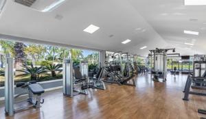 a gym with a row of treadmills and exercise equipment at Condomínio Ilhas Park Xangri-lá in Xangri-lá