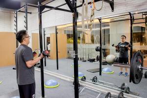 two men standing in a gym with weights at Tara Hotel Yogyakarta in Yogyakarta